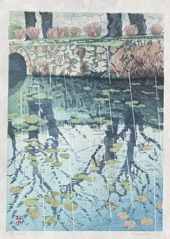 Pluie silencieuse de Junichi Mibugawa est une estampe japonaise raffinée représentant un pont en pierre sous une pluie délicate, avec des reflets d’arbres et des nénuphars flottants. Numéro 1 sur 200 dans une édition limitée, cette œuvre rare allie sérénité et maîtrise artistique, idéale pour les amateurs d’art japonais et de paysages poétiques.