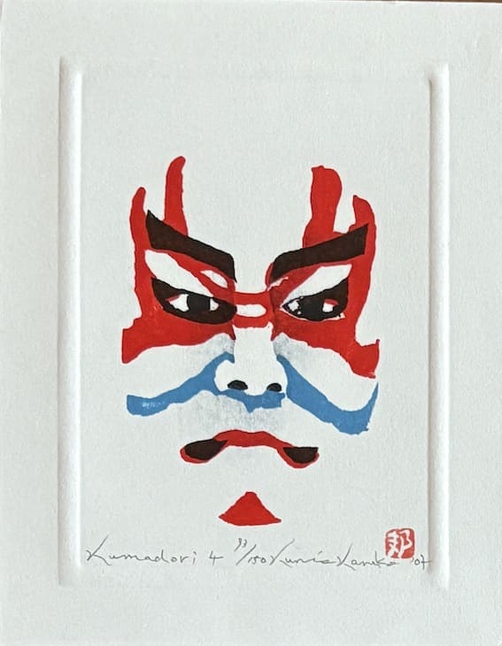 Estampe japonaise contemporaine en édition limitée (150 exemplaires) représentant un visage kabuki stylisé, avec des lignes rouges et bleues évoquant l’art du kumadori. Une œuvre graphique et moderne signée Kunio Kaneko.