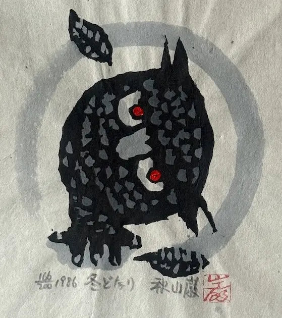 Estampe japonaise d’Iwao Akiyama intitulée L’hiver approche, représentant un hibou noir aux yeux rouges devant un cercle gris et deux feuilles.